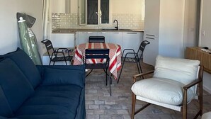 Un espacio habitable compacto con comedor, kitchenette y sofá.