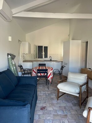 Ein kompakter Wohnbereich mit Essplatz, Küchenzeile und einer Couch.