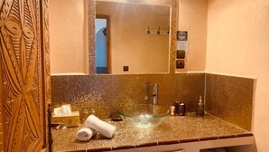 A bathroom with a glass bowl sink, a towel, and a mirror. - Villa Daba by Zelia en Exclusivité  (Essaouira)