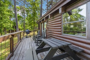 A wooden deck with picnic tables and a grill, surrounded by trees. - Pine Haven-Serene & Natural Cabin-7 mi to Downtown (Eureka Springs)