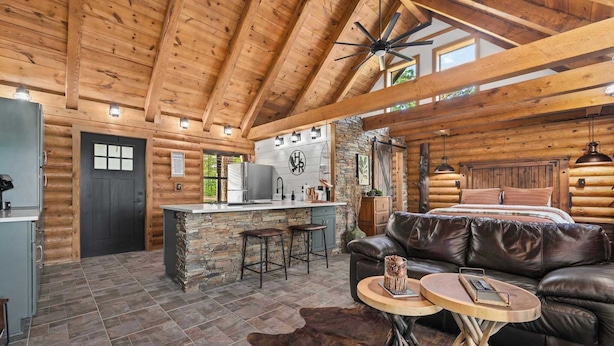 A log cabin interior with a kitchen, dining area, and a large bed. - Pine Haven-Serene & Natural Cabin-7 mi to Downtown (Eureka Springs)