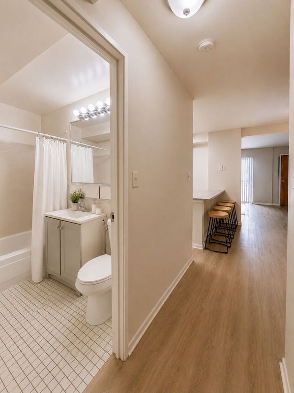 Un baño moderno con inodoro, lavamanos y ducha.