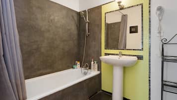 Un baño con bañera, lavamanos y ducha.