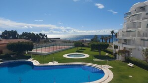 Ein Schwimmbad, ein Tennisplatz und Meerblick.