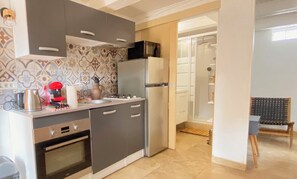 A compact kitchen with modern appliances, a microwave, and a sink. - Charming New Cottage with Pool near Uzès – Sleeps 2–3 (Saint-Siffret)