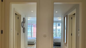 A modern interior with wooden floors, white walls, and a central light fixture. - Z - Market Residence 1D (Porto)