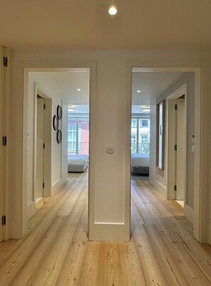 A modern interior with wooden floors, white walls, and a central light fixture. - Z - Market Residence 1D (Porto)