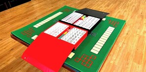 A wooden table with three card game boards.