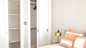 A bedroom with a bed, a nightstand, a lamp, and a wardrobe. - New York Style Stay near Central Park (New York)
