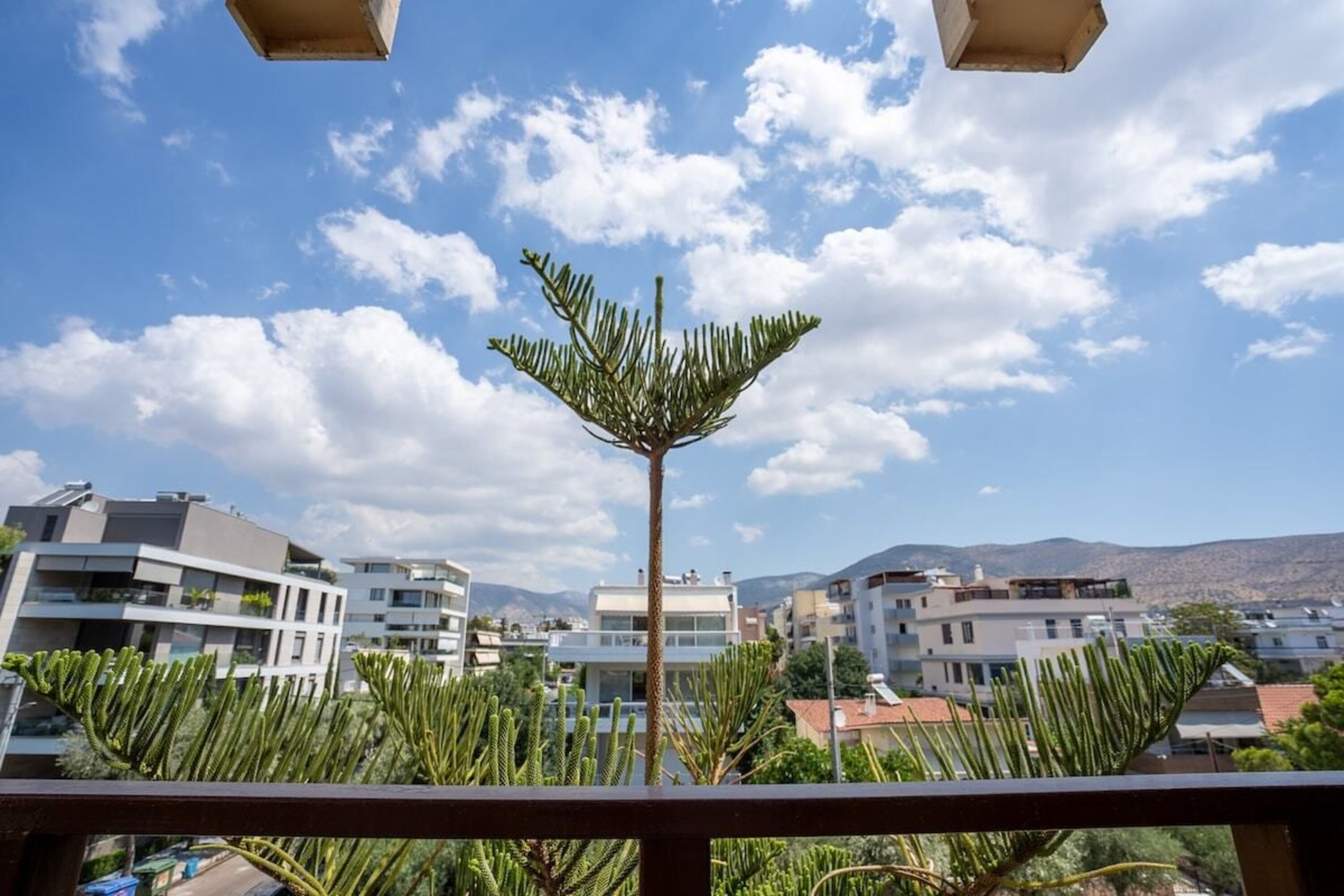 A balcony with a view of modern buildings and a clear sky.