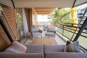 A balcony with a sofa, chairs, and a table. - Glyfada Prime Vacation Rentals (Glifada)