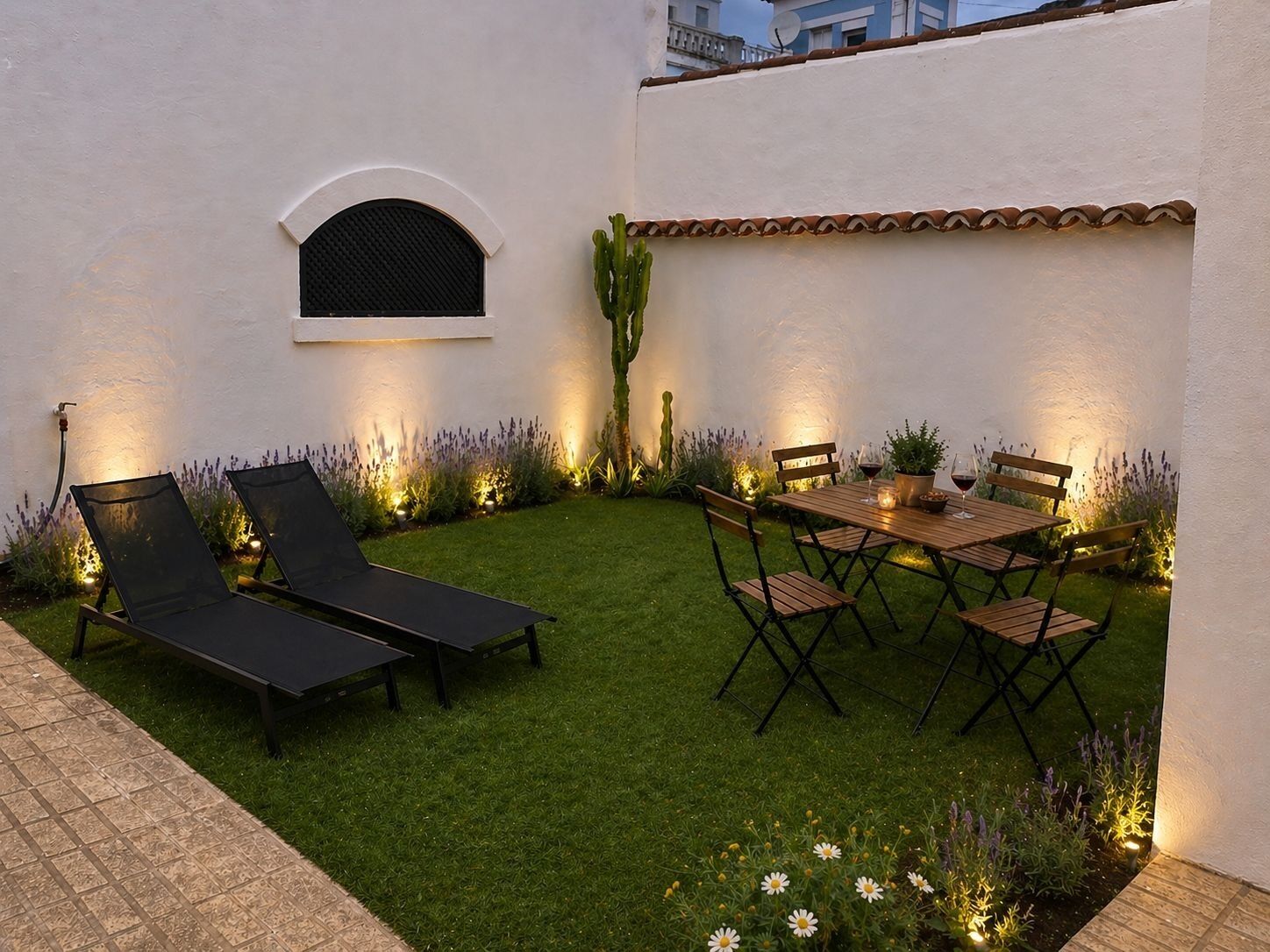 A patio with a table and chairs, a small window, and a cactus.