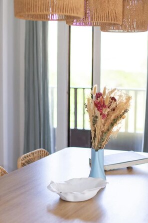 Ein Tisch mit einer Vase getrockneter Blumen und einer weißen Serviette.