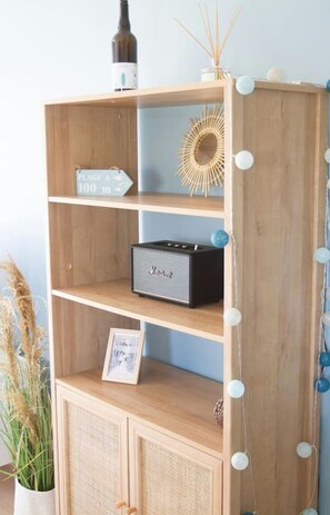 Ein Holzregal mit einem gerahmten Bild, einem kleinen Lautsprecher und Dekorationselementen.