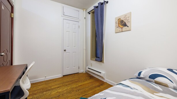 A bedroom with a bed, a desk, and a chair. - Enjoy Easy Access to the West side Manhattan (New York)
