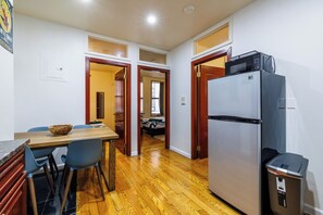 A kitchen with a refrigerator, microwave, and dining area with chairs and a table. - Enjoy Easy Access to the West side Manhattan (New York)