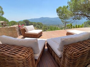 A wooden deck with wicker furniture and a view of mountains. - Quinta da Rampa - Arrábida (Azeitão)