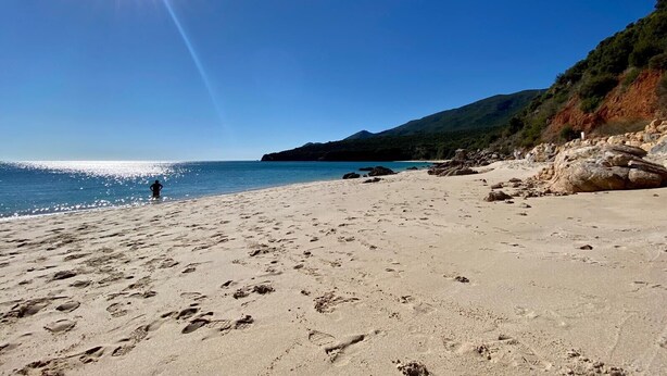 A beach with footprints, a clear sky, and a distant hiker. - Quinta da Rampa - Arrábida (Azeitão)