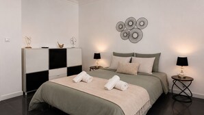 Un dormitorio moderno con cama, mesitas de noche y decoración en la pared.