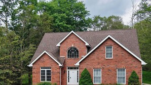 A brick house with a central entrance, two side entrances, and a symmetrical design. - Perfect Pocono Retreat / Golf / FirePit /Swimming Pool/BBQ near Waterparks (Tobyhanna)