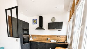 Eine moderne Küche mit einem Holzespeisetisch, einem Einbauofen und einer schwarzen Dunstabzugshaube.