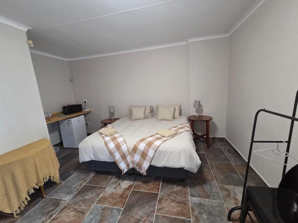 Una camera da letto con un letto, comodini, una scrivania e una sedia.