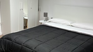 Una camera da letto con un letto, un comodino, una lampada e un armadio.