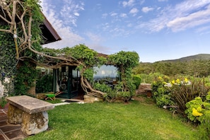 A garden with a stone bench, a stone wall, and a view of the countryside. - Villa Atlantico, nestled where Sintra Mountains meet Atlantic ocean (Colares)