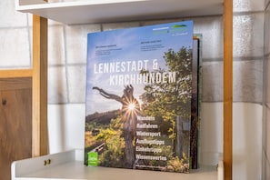 Kirja, jonka nimi on ”LENNESTADT & KIRCHHUNDEM” ja jonka kannessa on kaunis maisemakuva, on asetettu hyllylle.