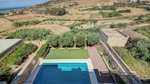 Una piscina con vista su campi a terrazze e una costa in lontananza.