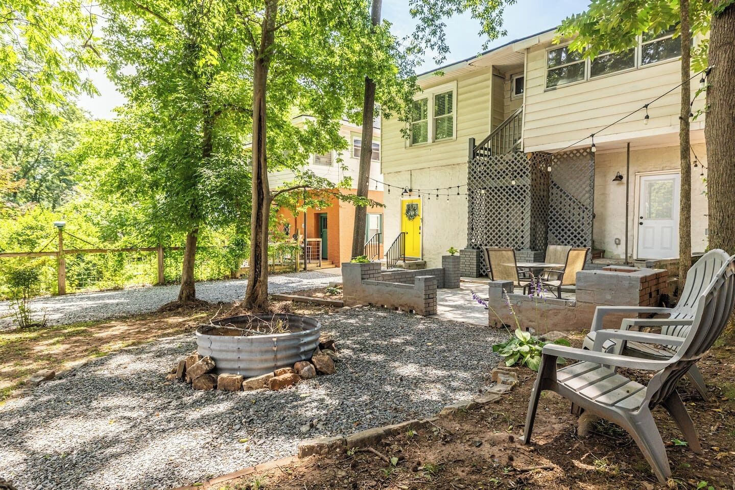 Eine Terrasse mit Gartenmöbeln, einem Feuerkorb und einem Gebäude mit überdachter Veranda.