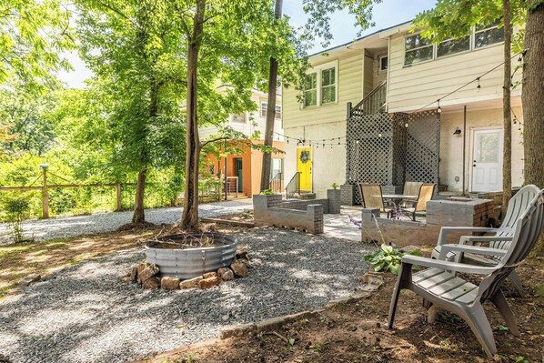 Un espace patio aménagé avec du mobilier d’extérieur, un foyer et un bâtiment doté d’un porche couvert.