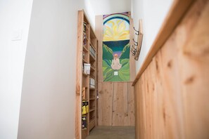 A narrow hallway with wooden walls and a wooden staircase.