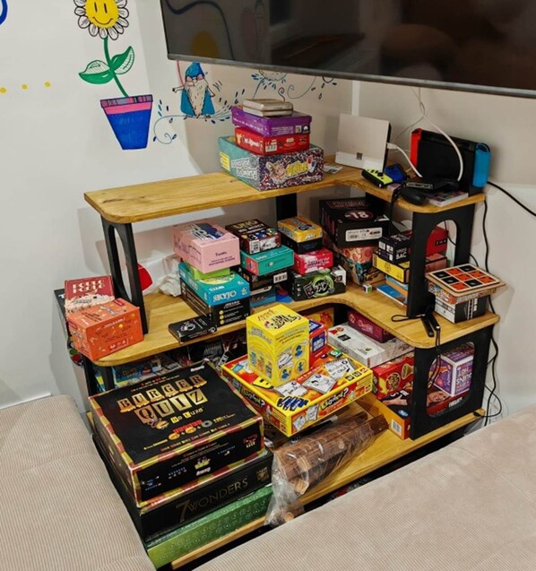 A shelf with various board games and puzzles.