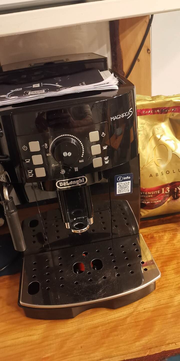 Eine Kaffeemaschine mit digitalem Display, Auffangschale und einem QR-Code.