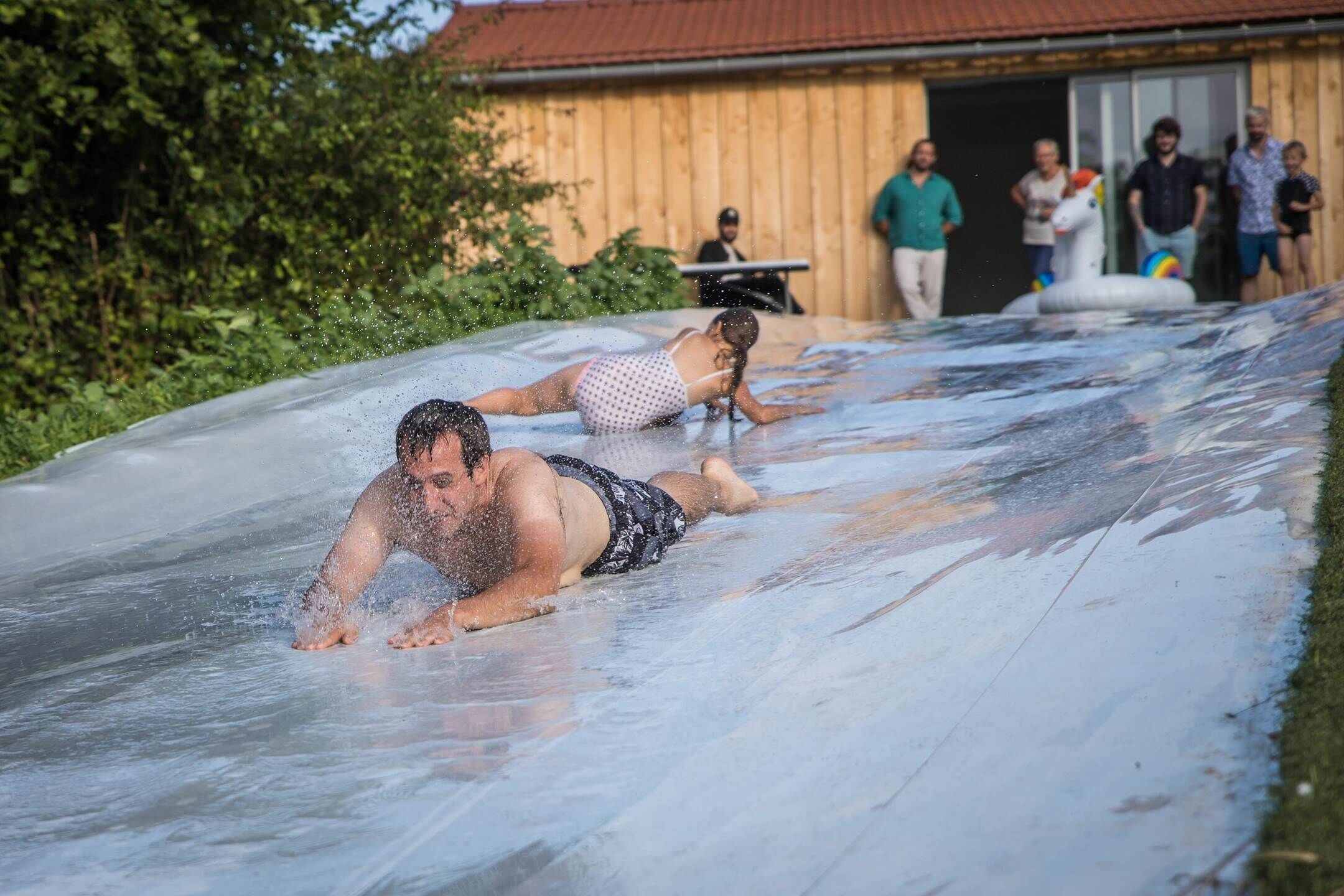 A water slide with people sliding down.