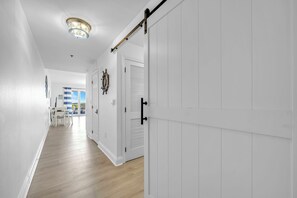 A hallway with white walls, a wooden floor, and a ceiling light fixture. - 🏖️Laketown Wharf 318~Walk to Beach~5 Pools~ Lake Views, Fountain Shows🏖️ (Panama City Beach)