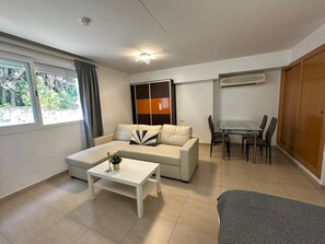 A modern living room with a sofa, coffee table, and dining area. - Studio Apartment 'Acogedor En La Playa' with Shared Pool, Wi-Fi and Air Conditioning (Marbella)