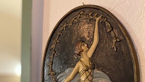Escultura na parede de uma bailarina.