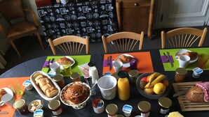 Uma mesa de jantar com diversos alimentos, utensílios e bebidas.