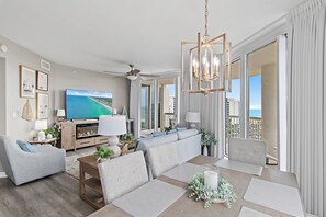 Ein modernes Wohnzimmer mit Fernseher, Sofa und Essbereich.