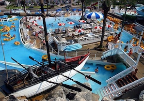 Ein Wasserpark mit mehreren Pools, Rutschen und einem Boot.
