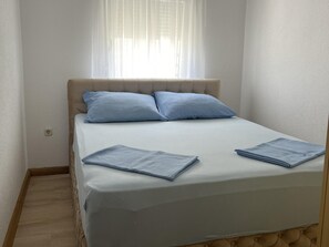 A single bed with a headboard, two pillows, and a folded blanket. - Apartment Lavaran 4 (Vir)
