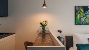 Una cocina moderna con comedor, un florero con flores y un cuadro en la pared.