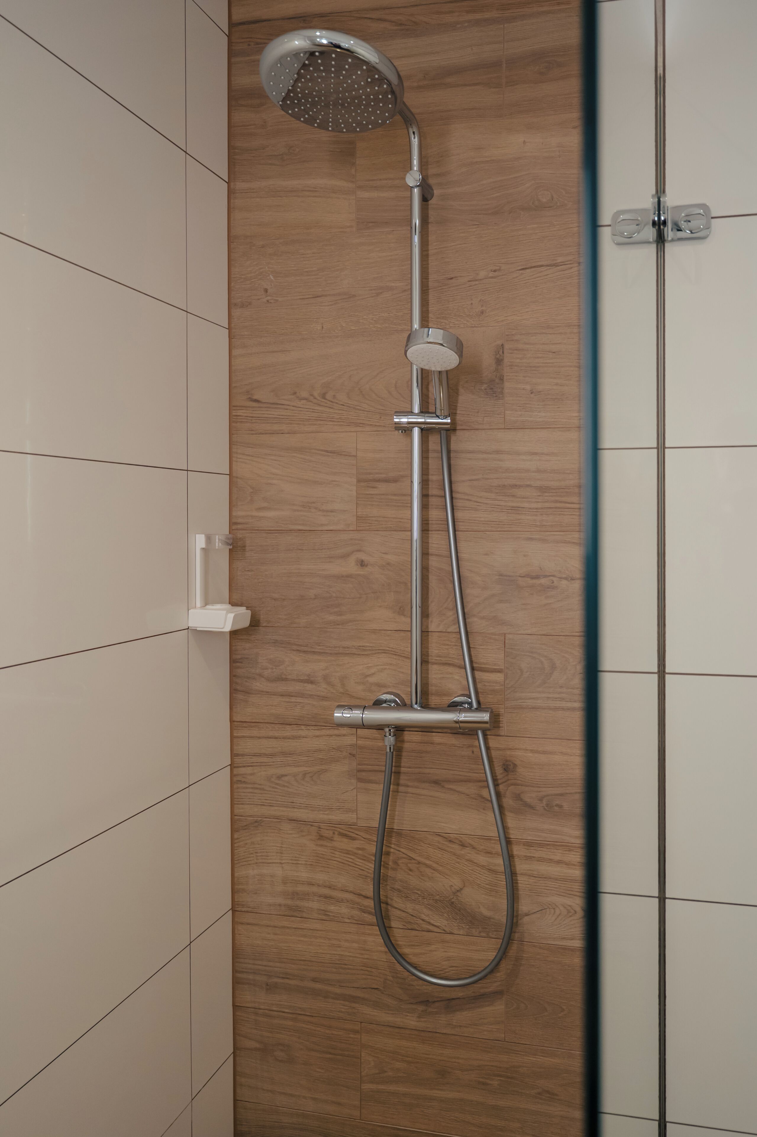 Eine Dusche mit Duschkopf und Brausehandstück.