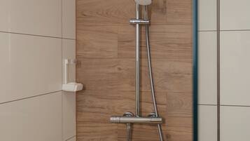 Eine Dusche mit Duschkopf und Brausehandstück.