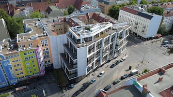 An aerial view of a multi-story building with a flat roof, surrounded by other buildings.