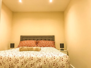 A bedroom with a bed, two bedside tables, and a headboard. - Apartment Sleeps 4 With Parking (Blakeney)