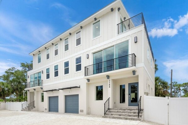 A two-story building with a flat roof, large windows, and a balcony on the upper floor.