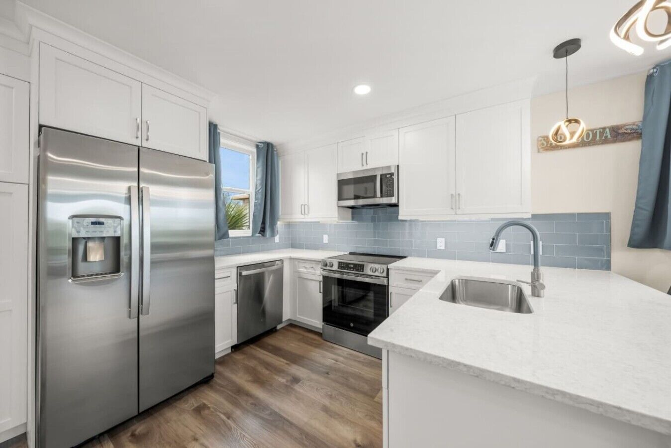 A modern kitchen with stainless steel appliances, a built-in microwave, and a dishwasher.